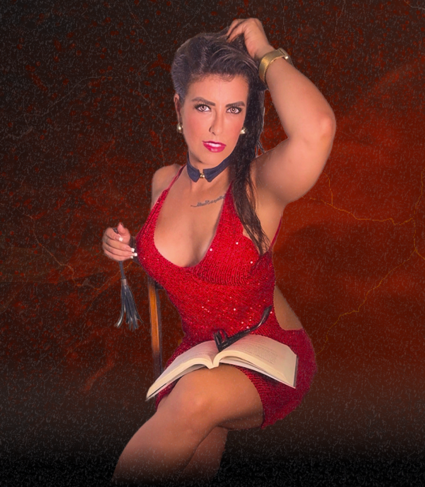 Lorene Patigra na Sala Secreta, vestida de vermelho, ensinando sobre desejo, performance e transmutação masculina.