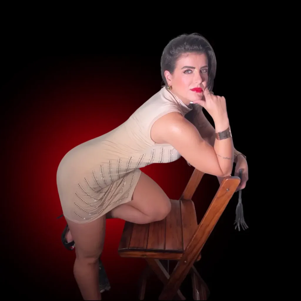 Lorene Patigra sentada na cadeira de forma provocativa, chamando atenção para os segredos que ensina sobre prazer e presença.